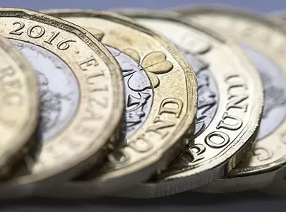 A close-up of British pound coins, showcasing their intricate design and varying denominations.