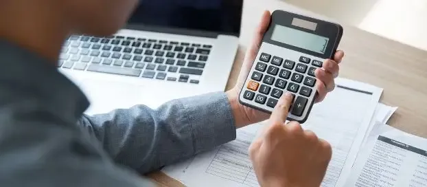 A person using a calculator to perform calculations.