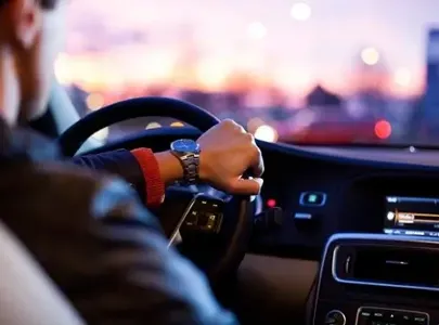 A man driving a car in a beautiful sunset.